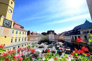 a city street with buildings and a clock tower at Hotel Goldener Adler in Bautzen