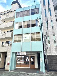 a blue building with a door in front of it at Guest House Re-worth Yabacho1 1F in Nagoya