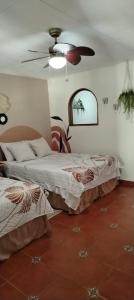 a bedroom with two beds and a ceiling fan at Casa Campana in Concepción de Ataco