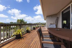 a wooden deck with a wooden table and chairs at Cable Bay Serenity in Cable Bay
