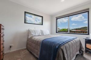 a bedroom with a bed and a large window at Cable Bay Serenity in Cable Bay +3 photos