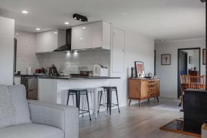 a kitchen and living room with a couch and a table at Cable Bay Serenity in Cable Bay