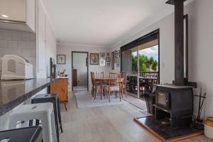 a kitchen with a stove and a dining room at Cable Bay Serenity in Cable Bay
