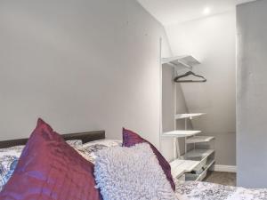 a bedroom with a bed with pillows and a shelf at Corner Spot in Hednesford +2 photos
