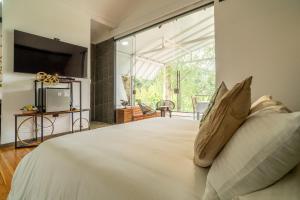 a bedroom with a large bed with a large window at Örök Landscape Hotel in Rionegro +91 photos