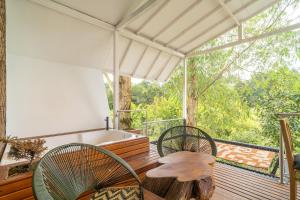 a porch with two chairs and a tub on a deck at Örök Landscape Hotel in Rionegro