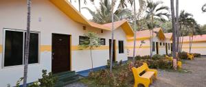 a row of houses with yellow chairs in front of them at Kuttralam Resorts in Kuttālam