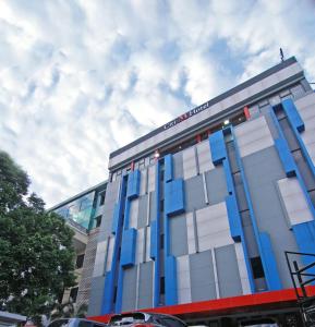 a building with a blue and white facade at Citi M Hotel Gambir in Jakarta