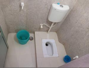 a small bathroom with a toilet and a bucket at Sri Hotel Ganga Couple&Family Friendly in Patna +17 photos
