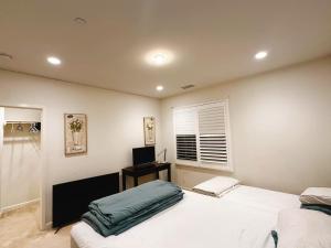 a bedroom with two white beds and a desk at FB Master in Irvine