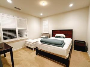 a bedroom with a bed and a desk and window at FB Master in Irvine