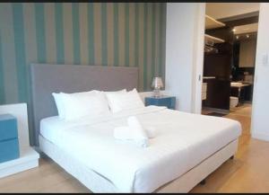 a bedroom with a large white bed with white pillows at Platinum Face suits in Kuala Lumpur