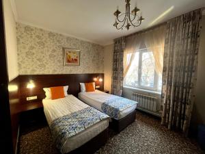 a hotel room with two beds and a window at Silk Way in Almaty