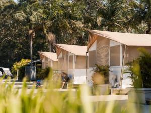 a man sitting in front of a house with tents at Tasman Holiday Parks - Jervis Bay in Huskisson +18 photos