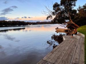 a man sitting on a dock next to a lake at Tasman Holiday Parks - Jervis Bay in Huskisson