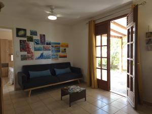 a living room with a couch and a table at Ti Sucrier Jaune - Douceur caraïbe vue mer in Le Carbet