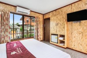 a bedroom with a bed and a flat screen tv at Chanta Boutique Place in Ubon Ratchathani