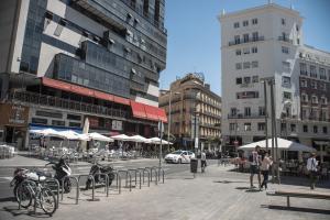 a city street with tables and chairs and buildings at Petit Palace Plaza España in Madrid