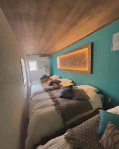 two beds in a room with blue walls at Gaju Camp in Wakayama