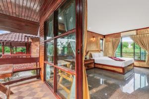 a bedroom with a bed and some windows at Chanta Boutique Place in Ubon Ratchathani
