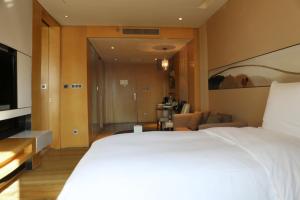 a hotel room with a bed and a television at Langham Place Xiamen in Xiamen