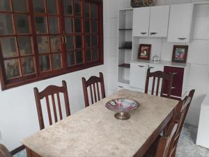 a kitchen with a table with chairs and a bowl on it at Casa Tia Celinha e Cafeteria in Teresópolis