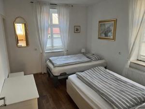 a room with two beds and a mirror and a window at Hugo zwei in Warburg