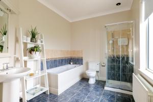 a bathroom with a tub and a toilet and a sink at Cozy Connemara Family Retreat in Derroogh +10 photos