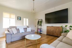 a living room with a couch and a flat screen tv at Cozy Connemara Family Retreat in Derroogh