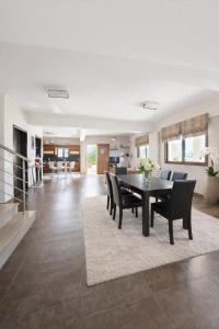 a dining room and living room with a table and chairs at Villa Anemos in Nafplio