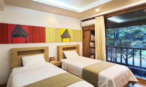 two beds in a room with a window at Nami Island Hotel Jeonggwanru in Chuncheon