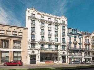 a large white building with cars parked in front of it at Mercure Lille Roubaix Grand Hôtel in Roubaix