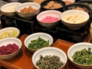 a table topped with bowls of different types of food at Hotel Monterey Kyoto in Kyoto +87 photos