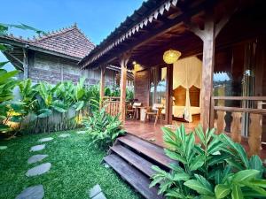 a porch of a house with a wooden bench at Sunshine dijoglo villa in Ubud