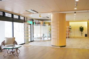a lobby with columns and a chair and a table at ホテル韮崎インター in Nirasaki