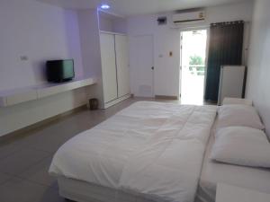 a large white bed in a room with a tv at Illusion Hostel & Club in Pattaya South +7 photos