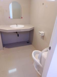a white bathroom with a sink and a toilet at Illusion Hostel & Club in Pattaya South