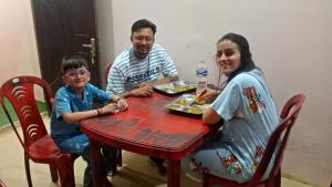 a man and a woman sitting at a table with a child at Mountain View Cottage Shivpuri Rishikesh in Rishīkesh +28 photos
