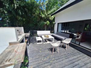 a wooden deck with a bench and a table and chairs at The White House @ Cintsa in Chintsa