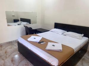 a bedroom with a large bed with towels on it at Samadhan lodge in Vangani