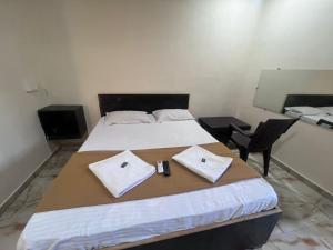 a bedroom with a bed with two towels on it at Samadhan lodge in Vangani