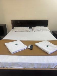 two beds with towels and a remote control on them at Samadhan lodge in Vangani