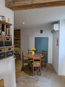 a kitchen with a table and chairs in a room at L’escale in Dieulefit
