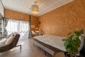 a bedroom with a bed and a chair at Jupiter 糸島市1棟貸し切り宿 in Itoshima +59 photos
