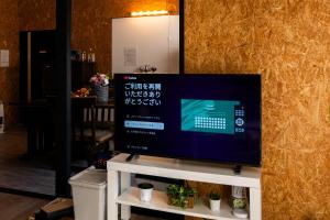 a flat screen tv sitting on top of a tv stand at Jupiter 糸島市1棟貸し切り宿 in Itoshima