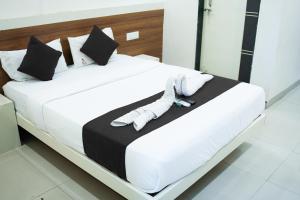 a white bed with white socks and shoes on it at Stay Prime, Balewadi in Pune