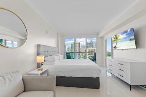 a white bedroom with a bed and a mirror at Arya Hotel & Suites in Miami