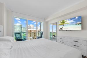 a bedroom with a white bed and a view of the beach at Arya Hotel & Suites in Miami