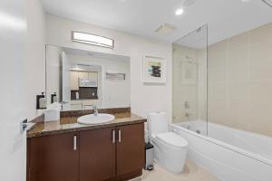 a bathroom with a sink and a toilet and a mirror at Arya Hotel & Suites in Miami +44 photos
