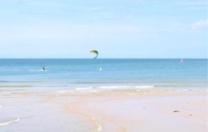 a person flying a kite on the beach at Mobile-Home Proche Mer 400M in Grandcamp-Maisy